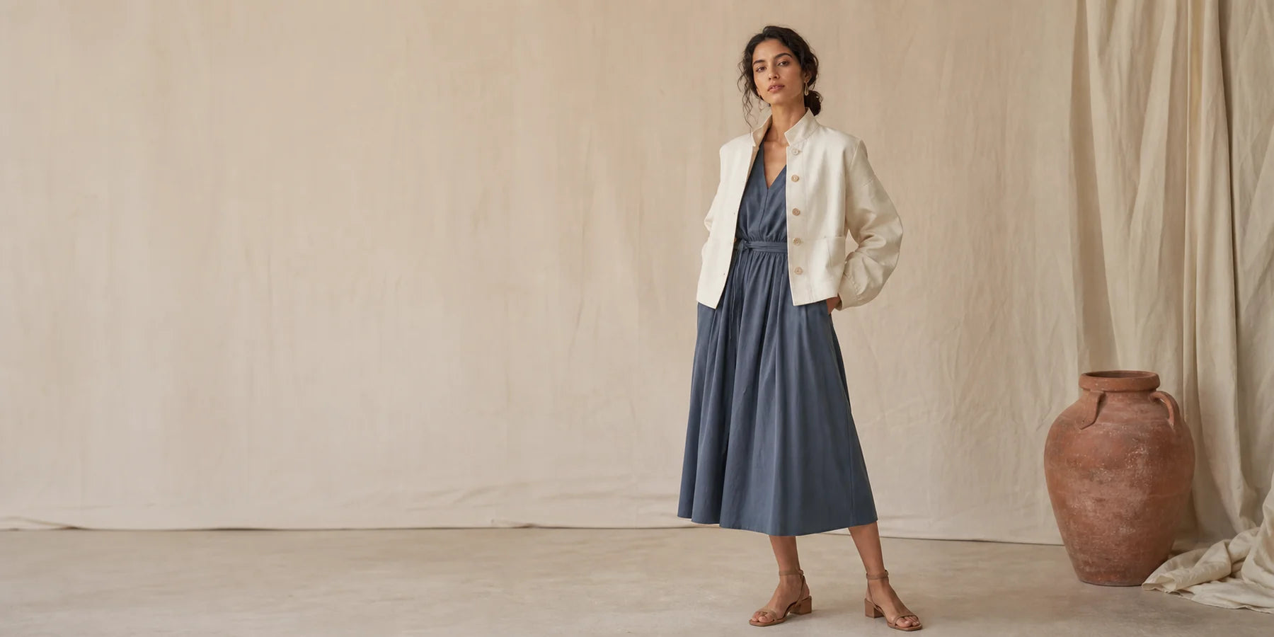 Model wearing ivory and slate ready-to-wear against a calico studio backdrop